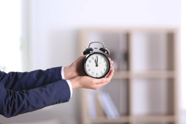 Çalar saat tutunarak işkadını arka plan bulanık. Zaman kavramı