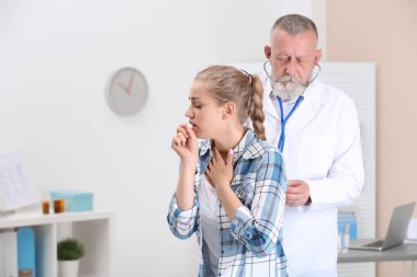 Doktor klinikte genç kadın öksürük incelenmesi