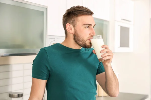 家庭でおいしい牛乳を飲む若い男 — ストック写真