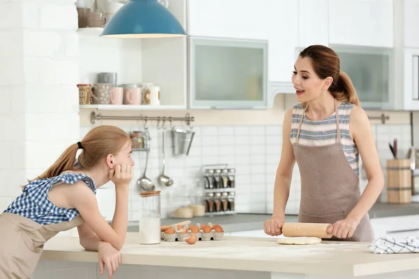 Anne ve kızı mutfakta masada hamur yapma
