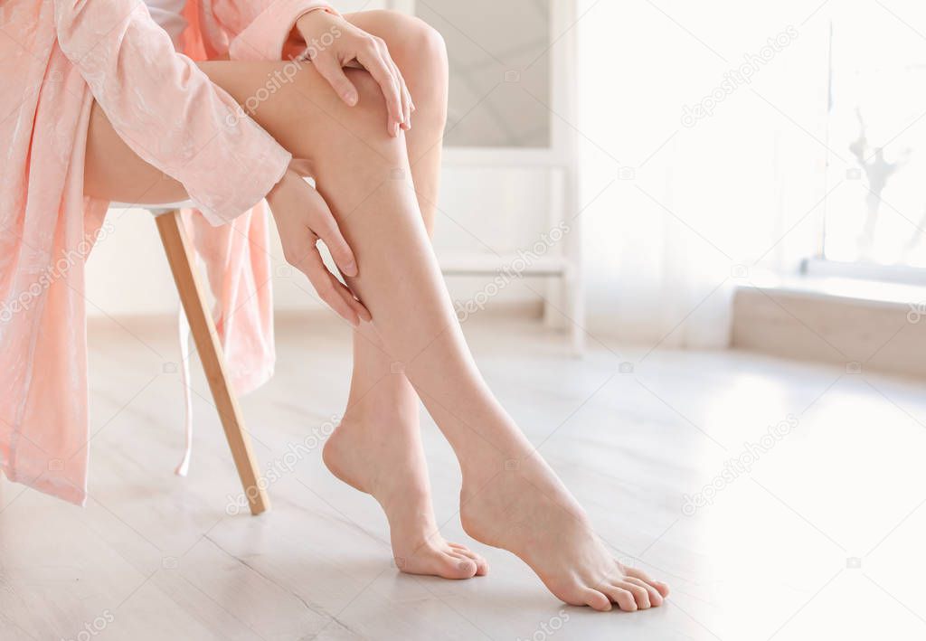 Young woman showing smooth silky skin after epilation at home