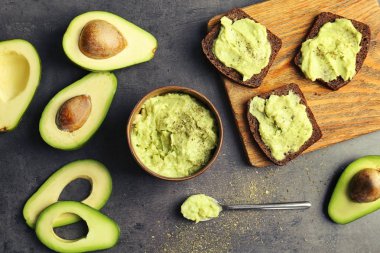 Avokado gri arka plan üzerinde yapılan guacamole ile düz yatıyordu kompozisyon