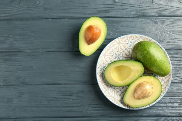 Plate Med Moden Avokado Trebakgrunn Sett Ovenfra – stockfoto