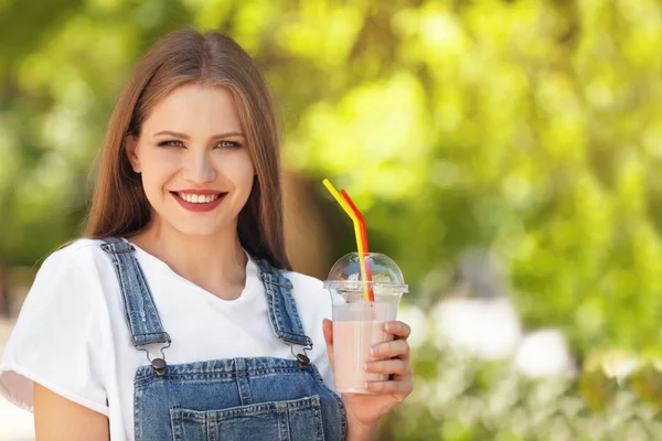 おいしいミルクセーキ屋外のカップを持つ若い女性 — ストック写真