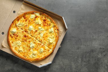 Gri zemin üzerine lezzetli pizza ile karton kutu