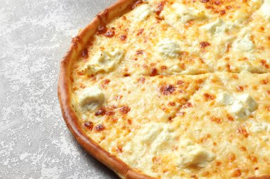 Gri zemin üzerine lezzetli sıcak peynirli pizza