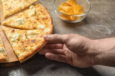 Lezzetli peynir pizza masadaki adam alarak dilim