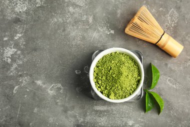 Matcha çay kase, çırpma teli ve yeşil yaprakları masada, üstten görünüm