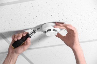 Genç erkek teknisyen duman alarm sistemi kapalı yükleme
