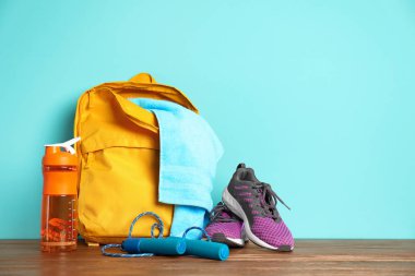 Spor çanta ve spor malzemeleri ahşap zemin renkli arka plan üzerinde
