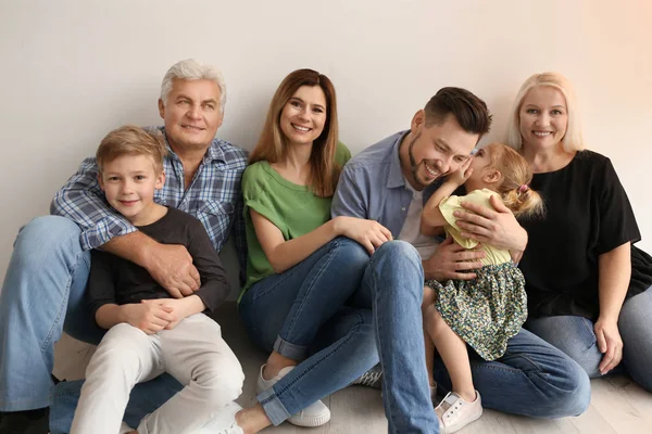 Família Feliz Com Crianças Bonitos Sentados Chão Perto Parede Luz — Fotografia de Stock