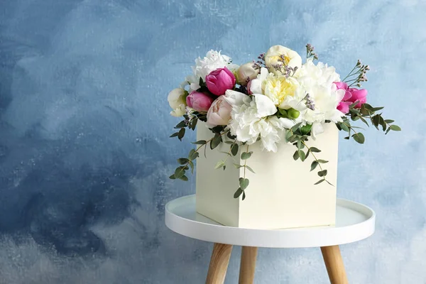 Caixa Com Buquê Flores Bonitas Mesa Contra Fundo Cor — Fotografia de Stock