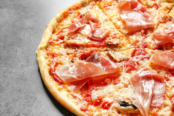 Gri zemin üzerine pastırma ile lezzetli pizza