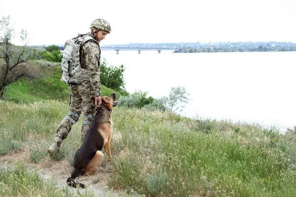 Alman çoban köpek açık havada ile askeri üniformalı erkeklere