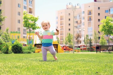 Şirin bebek kız açık havada güneşli günde yürümeyi öğrenme