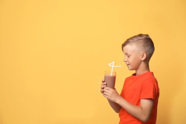 Bardak muzlu süt renkli arka plan üzerinde olan küçük çocuk