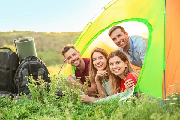 Group of happy young people in camping tent