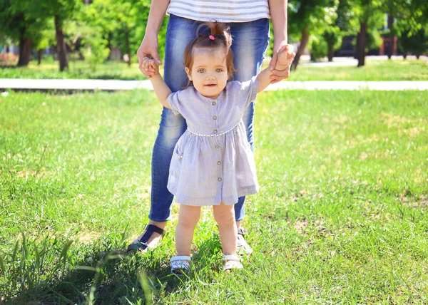 Schattig Babymeisje Moeder Handen Houden Terwijl Het Leren Lopen Buiten — Stockfoto