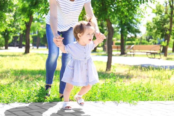 Schattig Babymeisje Moeder Handen Houden Terwijl Het Leren Lopen Buiten — Stockfoto