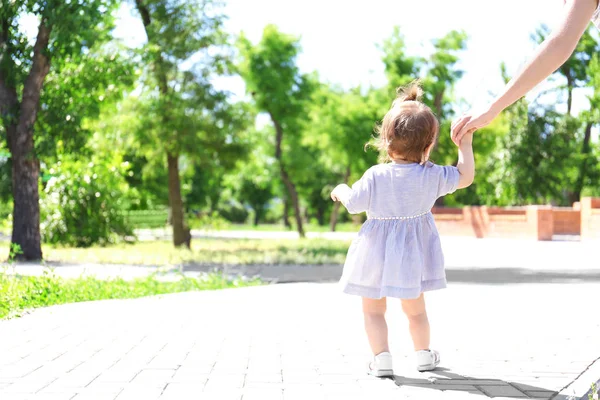 Adorable Niña Sosteniendo Mano Madre Mientras Aprende Caminar Aire Libre — Foto de Stock