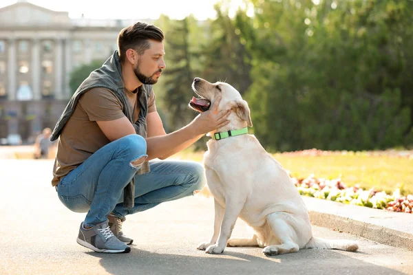 屋外のオーナーとかわいい黄色いラブラドル レトリーバー犬 — ストック写真
