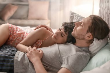 Evde yatakta uyuyan genç güzel Çift