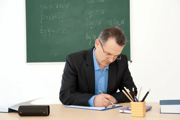 男性教師が教室内のテーブルでの作業 — ストック写真