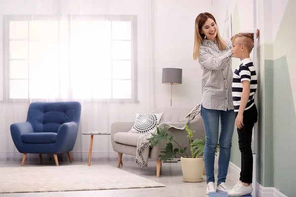 Mujer Joven Midiendo Altura Hijo Casa — Foto de Stock