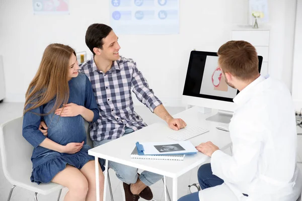 Gynecology consultation. Future parents with doctor in hospital