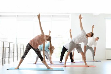 Bir grup insan pratik yoga kapalı spor giyim