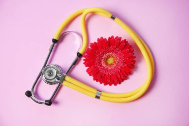 Kompozisyon stetoskop ile yat ve renk arka plan üzerinde çiçek. Jinekolojik Check-up