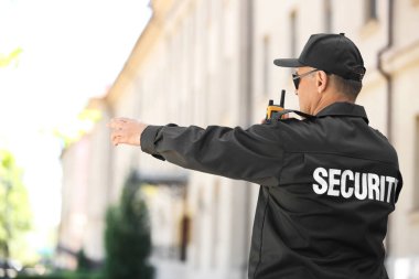 Erkek güvenlik görevlisi taşınabilir radyo vericisi açık havada kullanma