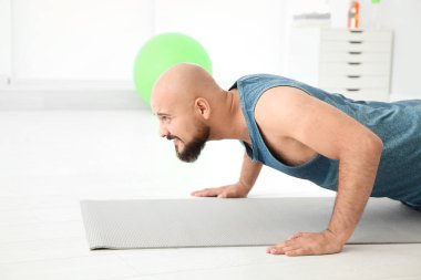 Kattaki spor salonunda egzersiz yapan kilolu erkek