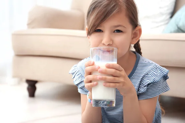 家で牛乳を飲むかわいい女の子 — ストック写真