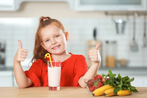 キッチンでおいしい牛乳を振るのガラスを持つ少女 — ストック写真