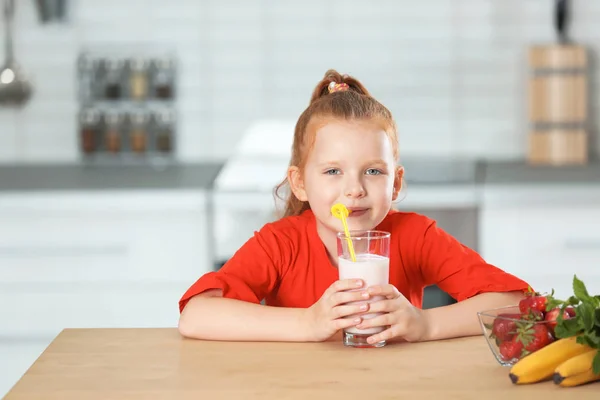 キッチンでおいしい牛乳を振るのガラスを持つ少女 — ストック写真