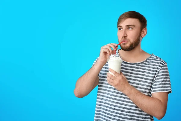 Ung Man Med Kopp Läcker Milkshake Färgbakgrund — Stockfoto