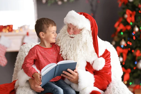 Kapalı otantik Noel baba nın kucağına otururken kitap okuma ufaklık