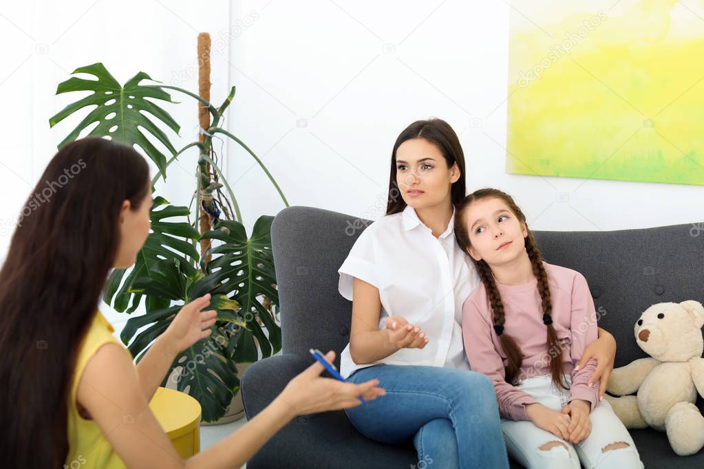 Young woman and her daughter having appointment with child psychologist in office