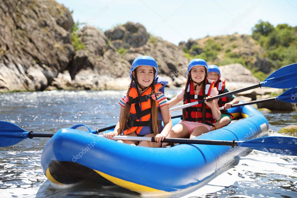 Little children kayaking on river. Summer camp