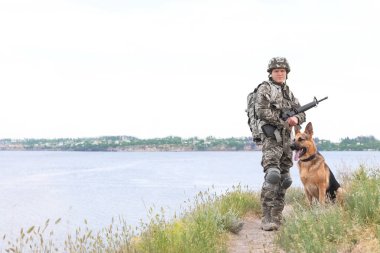 Alman çoban köpeği Nehri yakınında ile askeri üniformalı erkeklere
