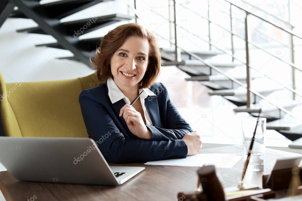 Female lawyer working at table in office