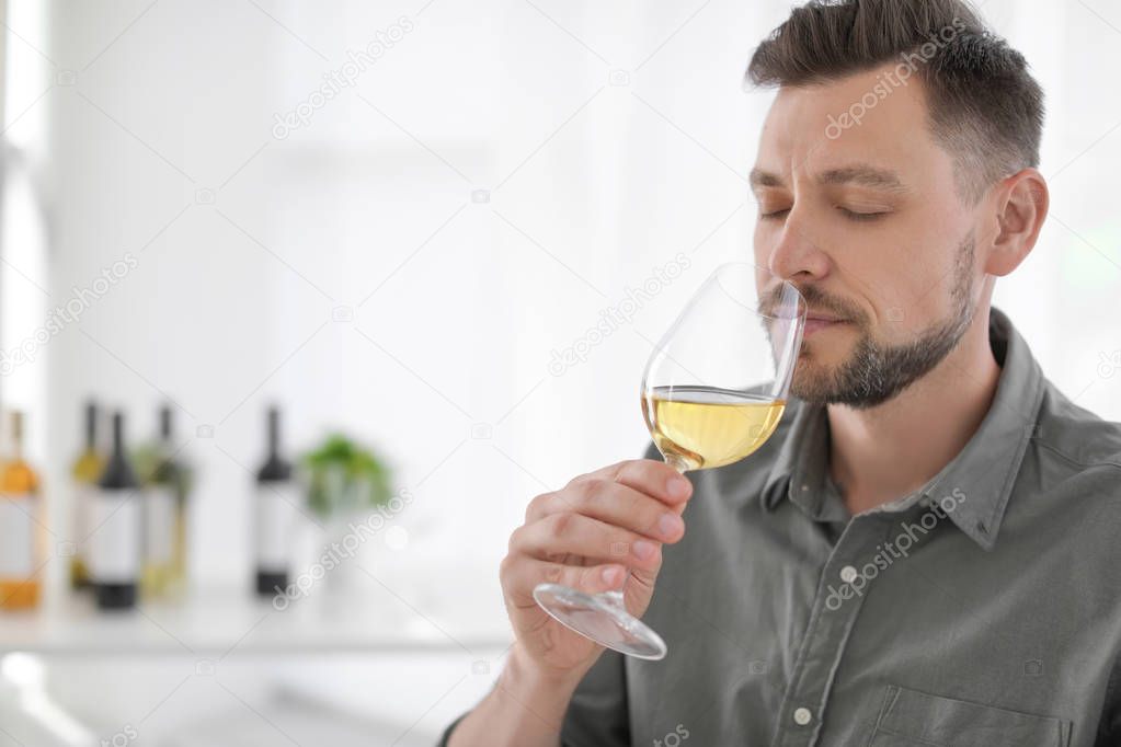Young man with glass of wine indoors