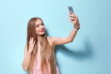Selfie renk arka plan üzerinde alarak çekici genç kadın
