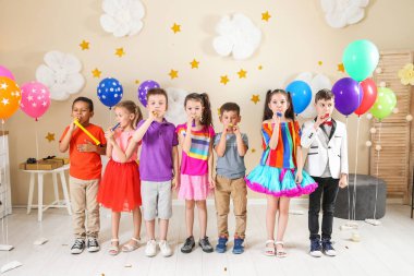 Adorable children with party blowers indoors. Birthday celebration clipart