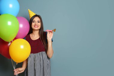 Parlak balonlar ve parti üfleyici renk arka plan üzerinde olan kadın. Doğum günü kutlaması