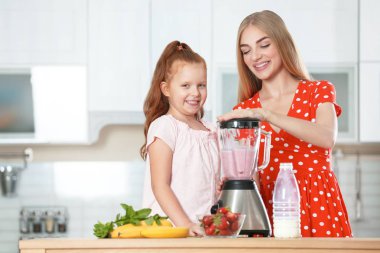 Anne ve kızı mutfakta lezzetli milkshake hazırlanıyor