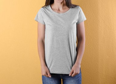 Gri t-shirt renk arka plan üzerinde genç kadın. Mockup tasarım için