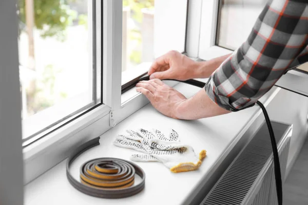 Young Man Putting Sealing Foam Tape Window Indoors — Stock Photo, Image