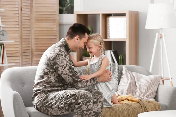 Küçük kızı evde kanepe ile askeri üniformalı genç adam